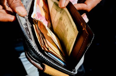 Eller sokakta cüzdandan para çıkarıyor, Hindistan rupisi erkek cüzdanında.