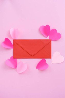 ile davet pembe bir arka plan üzerinde kırmızı zarf.