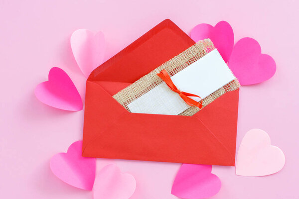 красный конверт с приглашением на розовый фон
.
