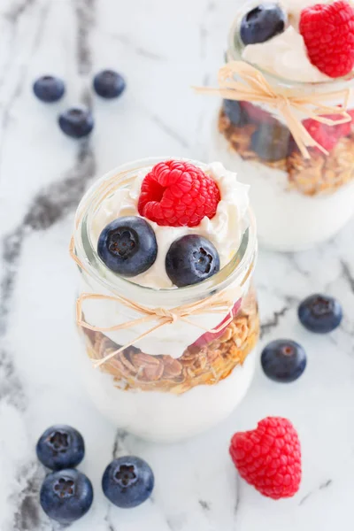 Breakfast of granola from yogurt, cereals, berries and cream in a glass — Stock Photo, Image