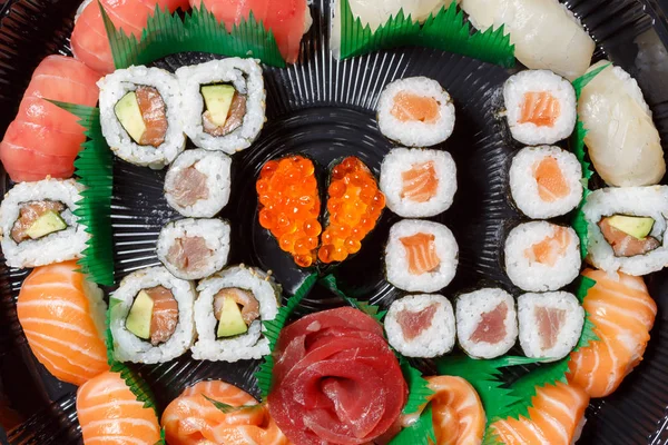Duży zestaw sushi i rolkach widok z góry. Dużo jedzenia w jednej tablicy. Potrawy z surowych ryb Japoński żywności. Danie w stylu romantycznym. Kocham cię. Serce z kawiorem czerwonym ryb — Zdjęcie stockowe