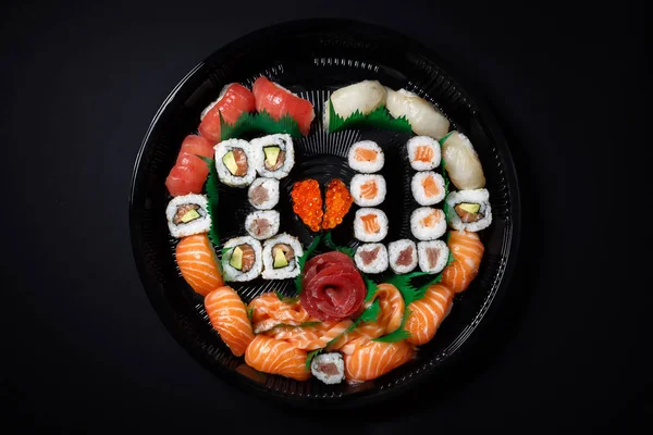 Suşi ve rulo büyük bir set yukarıdan görüntüleyin. Bir sürü yemek bir plaka. Çiğ balık Japon mutfağının yemeklerini. Romantik tarzda bir yemek. Seni seviyorum. Kalp kırmızı balık havyar ile