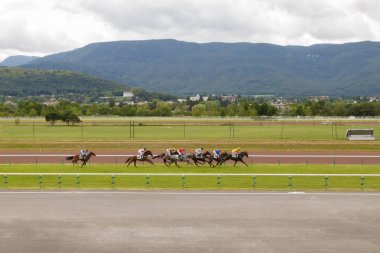 Horses and riders during galloping races at the racetrack. Hippodrome of France, the city of Divonne les ban. July 14, 2016 clipart