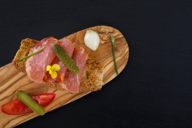 Ham İspanyolca dilim lomo tahıllar ile gevrek ekmek kırıntıları üzerinde ham. Yukarıdan yiyecek görünümünün resmi.