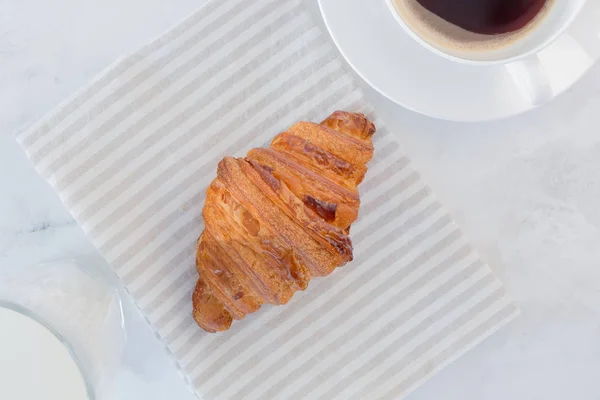 French croissant with coffee and a glass of milk on the table top view. European breakfast — Stock Photo, Image