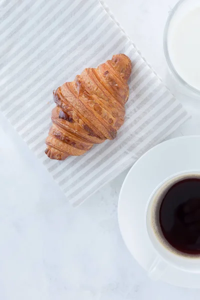 French croissant with coffee and a glass of milk on the table top view. European breakfast — Stock Photo, Image