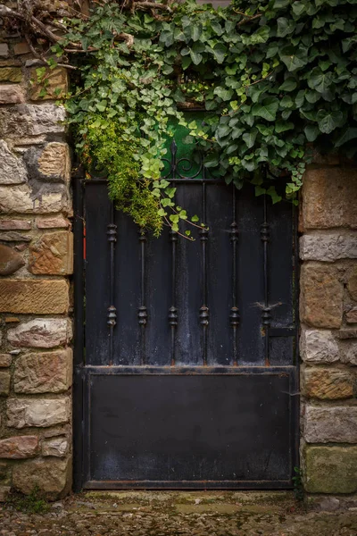 入口有一个黑色的门框到老建筑 有石头装饰砖的墙 — 图库照片