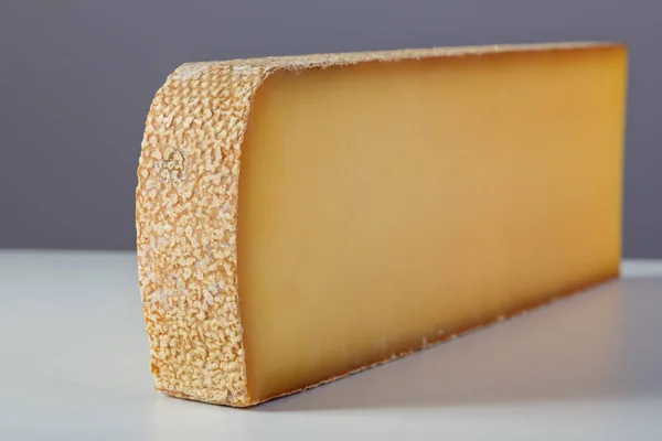 一大块牛奶乳酪在灰色背景 — 图库照片