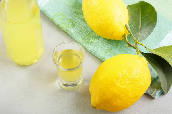 Limoncello hafif bir arka plan üzerinde. Ev yapımı likör Sicilya limon yaz geleneksel İtalyan içki. Alkollü içki sarıdır. meyve mamuller.