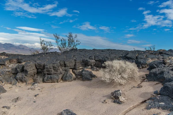 Beautiful Desert scene showing ancient lava flow against a cloudy blue sky in the Mojave Desert off of route 66