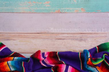 Beyaz ahşap zeminde renkli battaniyeler yatıyordu.