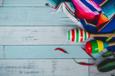 Mexican maraca put on colorful blanket on wooden floor