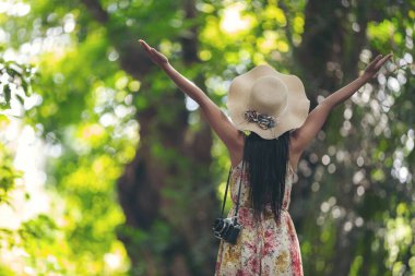 The back of the happiness girl wearing a straw hat in the garden