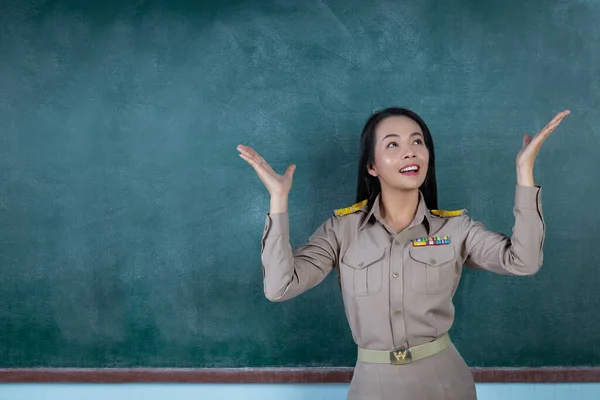 happy thai teacher in official outfit  acting in front of  backboard
