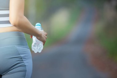 Close-up women holding water in exercise clothes