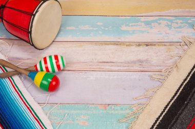 colorful Mexican maraca and mexican drum put on wooden floor