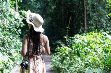The back of the happiness girl wearing a straw hat in the garden