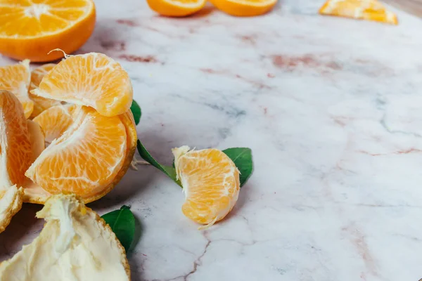 Fresh oranges, peeled oranges and leaves, top view.