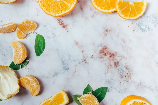 Fresh oranges, peeled oranges and leaves, top view.