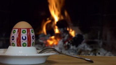 Paskalya Tatili. Bir Paskalya yumurtası şöminenin arka planında çay kaşığıyla tezgahta durur..