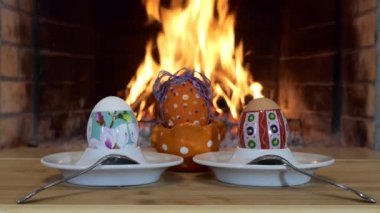 Paskalya Tatili. Çok renkli yumurtalar şöminenin arka planında çay kaşıklarıyla tezgahta duruyor..