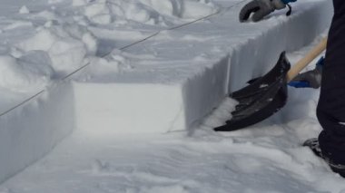 Igloo. Adamın biri Igloo yapmak için oyulmuş bir kar bloğu alıyor. Kapatın. Novosibirsk, Rusya / Sibirya, Şubat / 15 / 2020, yıllık tatil 