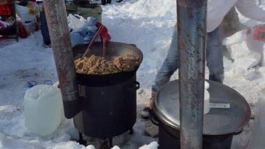 Basit bir yemek. Aşçı büyük bir kazanın tabağına karabuğday lapası koyar. Sibirya.