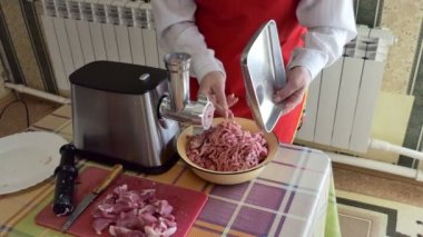 Basit bir yemek. Bir kadın kıyma makinesinin parçalarını kıyma yaptıktan sonra parçalara ayırıyor..