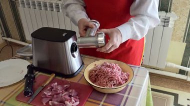 Basit bir yemek. Bir kadın kıyma makinesinin parçalarını kıyma yaptıktan sonra parçalara ayırıyor..
