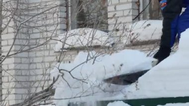 Kar temizliği. Adamın biri kar küreğiyle evin garajından kar dökmek için merdivenleri çıkıyor. Sibirya 'da. kaybet.