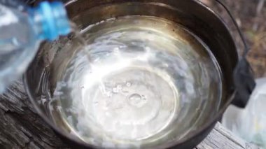 Doğadaki maceralar. Temiz su şişeden tencereye akar. Kapat..