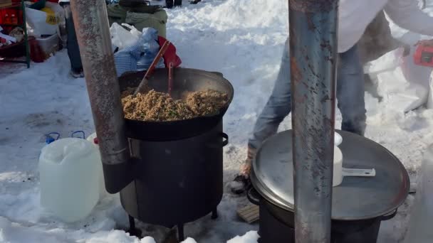 요리사는 커다란 가마솥에서 호밀죽을 놓는다 시베리아 — 비디오