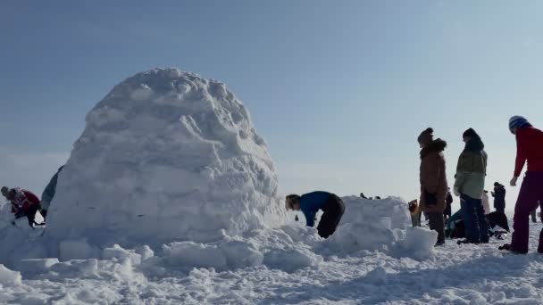 2020年2月15日 俄罗斯 西伯利亚的Novosibirsk 一年一度的假日 爱斯基摩市 参与者和观众用雪建造了一个Igloo 女队的一名队员用铲子清扫雪地的入口 — 图库视频影像