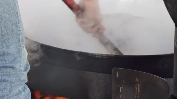 简单的晚餐 厨师把荞麦粥与鸡肉和调味品混合在屋外炉子上的大锅里 靠近点西伯利亚 — 图库视频影像