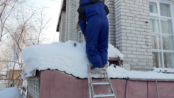 雪地清空一个人爬上楼梯 用铲子把雪从房子的车库倒了出来 西伯利亚 — 图库视频影像