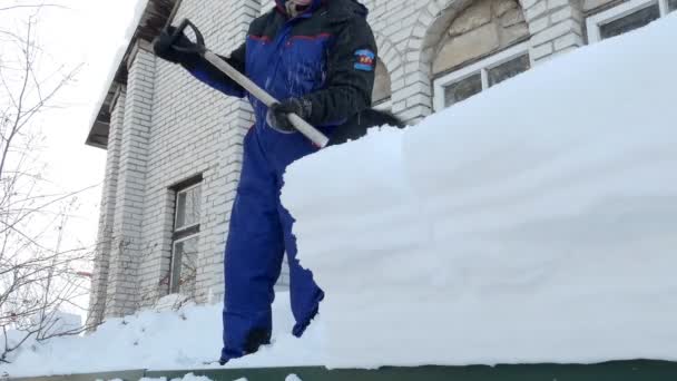 雪のクリアランス 男は雪のシャベルで家のガレージから雪をダンプするために階段を登る シベリアだ 失せろ — ストック動画