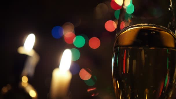 圣诞节 在香槟酒杯中 在蜡烛和闪烁的彩灯的衬托下 泡沫四起 背景录像 靠近点 — 图库视频影像
