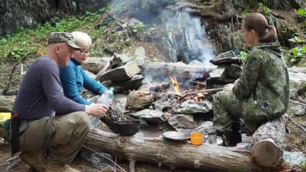 大自然的冒险 一个人从瓶子里把干净的水倒入锅里 用火煮汤 西伯利亚 — 图库视频影像