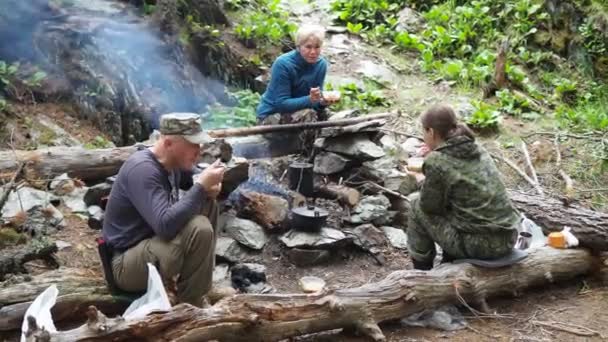 简单的晚餐 一个男人和一个女人吃着生火的食物做饭 西伯利亚 — 图库视频影像