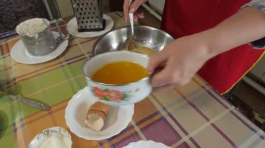 Basit yemek, turta yapmak. Bir kadın şekerle dövülmüş yumurtalara erimiş tereyağı döker. Kapatın. Sibirya.