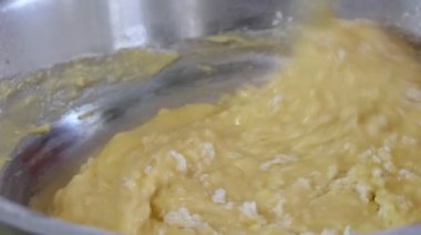 Basit yemek, turta yapmak. Bir kadın hamur yapmak için un ve malzemeleri bir kasede karıştırmak için kaşık kullanır. Kapatın. Sibirya.