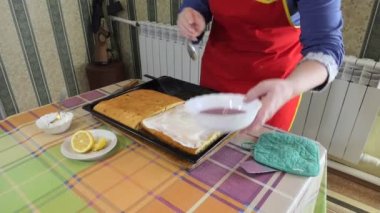 Basit yemek, turta yapmak. Bir kadın pasta yapmak için turtanın yarısına reçel sürüp reçel sürüyor. Genel plan. Sibirya.