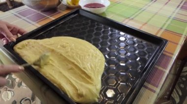 Basit yemek, turta yapmak. Kadın sıvı hamuru pişirme tepsisine bir kaşıkla yayar, pişirmek için istenen şekli verir. Sibirya.