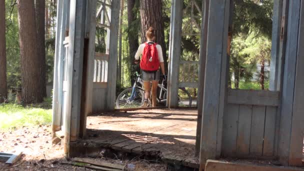 超自然现象 超自然现象 一位年轻的骑自行车的女骑手正在检查森林里被毁的旧凉亭 西伯利亚 — 图库视频影像