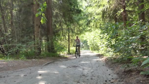 自転車だ 森の中で自転車に乗っている若い女性 シベリア — ストック動画