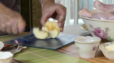 Noel zamanı. Yeni yıl. Basit bir yemek. Bir kadın, neşeli bir tavuğu doldurduğu için elma kesiyor. Kapat..