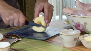 Noel zamanı. Yeni yıl. Basit bir yemek. Bir kadın, neşeli bir tavuğu doldurduğu için elma kesiyor..