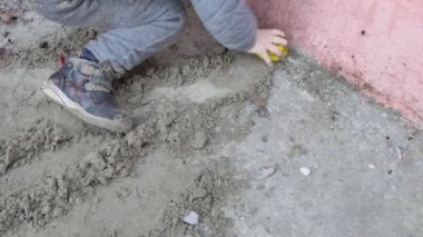 Yavrum. Kumda oyuncaklarla oynayan bir çocuğun elleri. Yakın çekim..
