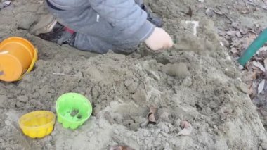 Çocuklar işte. Kumda oynayan bir çocuğun elleri. Yakın çekim..