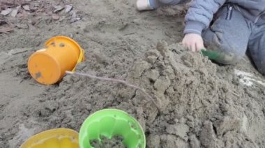 Çocuklar işte. Kumda oynayan bir çocuğun elleri. Yakın çekim..
